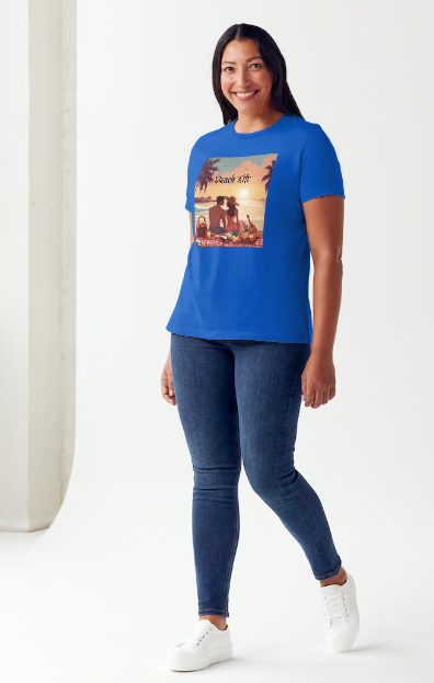 "Embrace adventure in our "Beach Life" cotton tee! This Women's T-shirt is featuring a relaxed fit that transports you to a tropical paradise with its picnic scene of a couple enjoying the sunset over the ocean. Bring the beach life with you wherever you go!" Available in Blue or Black colors. This is part of the Mike Roxly Collection.