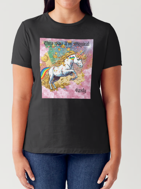 This is a black t-shirt entitled "they say I'm magical", features a White unicorn with a blinding light from its' horn, a golden mane and a rainbow tail galloping through cotton candy pink clouds filled with raining golden coins and a multicolor background. This shirt is for the bold unapologetically yourself type. YOLO. This is part of the Mike Roxly Collection.