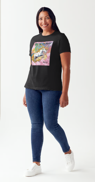 This is a black t-shirt entitled "they say I'm magical", features a White unicorn with a blinding light from its' horn, a golden mane and a rainbow tail galloping through cotton candy pink clouds filled with raining golden coins and a multicolor background. This shirt is for the bold unapologetically yourself type. YOLO. This is part of the Mike Roxly Collection.