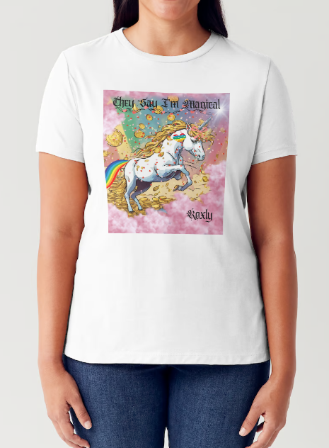 This is a black t-shirt entitled "they say I'm magical", features a White unicorn with a blinding light from its' horn, a golden mane and a rainbow tail galloping through cotton candy pink clouds filled with raining golden coins and a multicolor background. This shirt is for the bold unapologetically yourself type. YOLO. This is part of the Mike Roxly Collection.