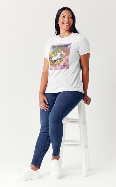 This is a black t-shirt entitled "they say I'm magical", features a White unicorn with a blinding light from its' horn, a golden mane and a rainbow tail galloping through cotton candy pink clouds filled with raining golden coins and a multicolor background. This shirt is for the bold unapologetically yourself type. YOLO. This is part of the Mike Roxly Collection.