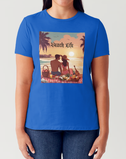 "Embrace adventure in our "Beach Life" cotton tee! This Women's T-shirt is featuring a relaxed fit that transports you to a tropical paradise with its picnic scene of a couple enjoying the sunset over the ocean. Bring the beach life with you wherever you go!" Available in Blue or Black colors.  This is part of the Mike Roxly Collection.