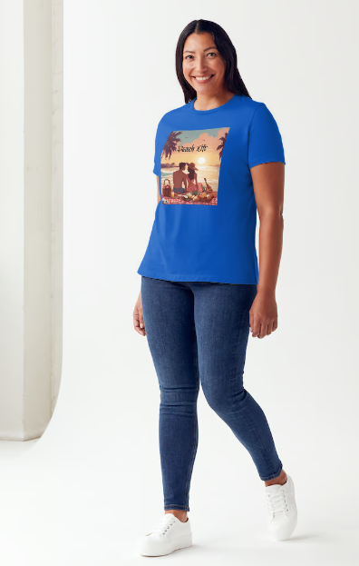 "Embrace adventure in our "Beach Life" cotton tee! This Women's T-shirt is featuring a relaxed fit that transports you to a tropical paradise with its picnic scene of a couple enjoying the sunset over the ocean. Bring the beach life with you wherever you go!" Available in Blue or Black colors.  This is part of the Mike Roxly Collection.