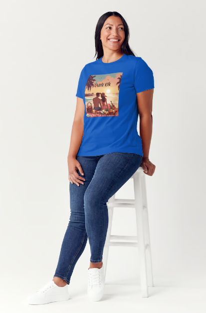 "Embrace adventure in our "Beach Life" cotton tee! This Women's T-shirt is featuring a relaxed fit that transports you to a tropical paradise with its picnic scene of a couple enjoying the sunset over the ocean. Bring the beach life with you wherever you go!" Available in Blue or Black colors.  This is part of the Mike Roxly Collection.