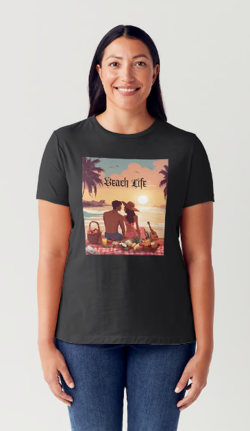 "Embrace adventure in our "Beach Life" cotton tee! This Women's T-shirt is featuring a relaxed fit that transports you to a tropical paradise with its picnic scene of a couple enjoying the sunset over the ocean. Bring the beach life with you wherever you go!" Available in Blue or Black colors.  This is part of the Mike Roxly Collection.