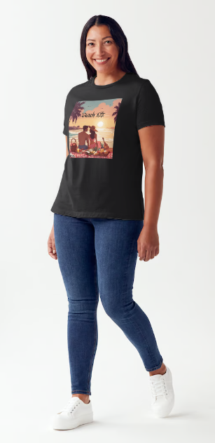 "Embrace adventure in our "Beach Life" cotton tee! This Women's T-shirt is featuring a relaxed fit that transports you to a tropical paradise with its picnic scene of a couple enjoying the sunset over the ocean. Bring the beach life with you wherever you go!" Available in Blue or Black colors.  This is part of the Mike Roxly Collection.